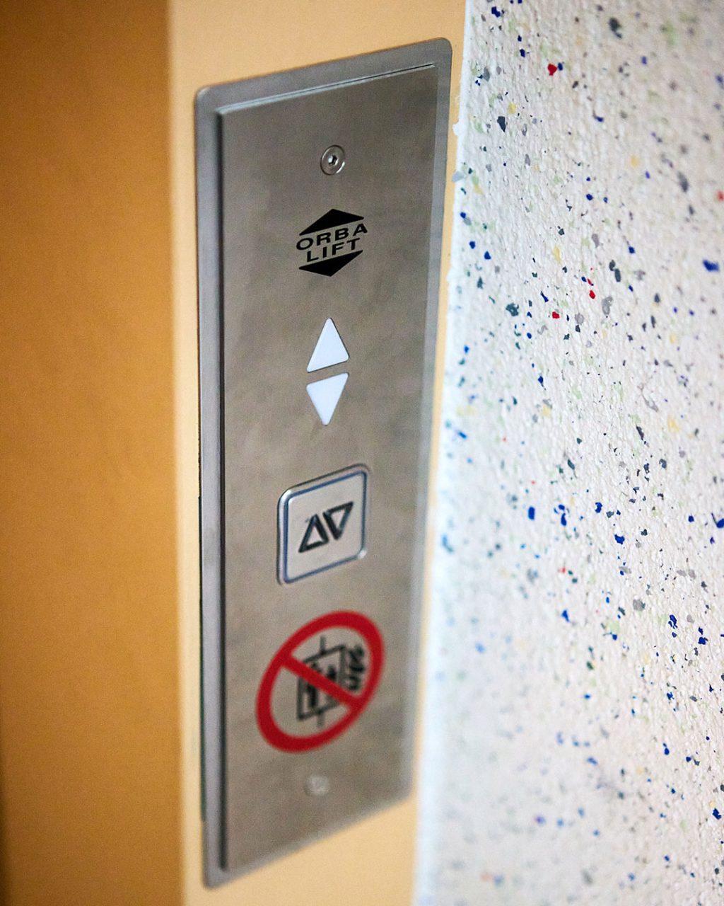 Nahaufnahme des ORBA LIFT Außen-Bedienfelds mit Rufpfeilen, Kontrollleuchte und Verbotsschild ('Transport von Gefahrgut untersagt')